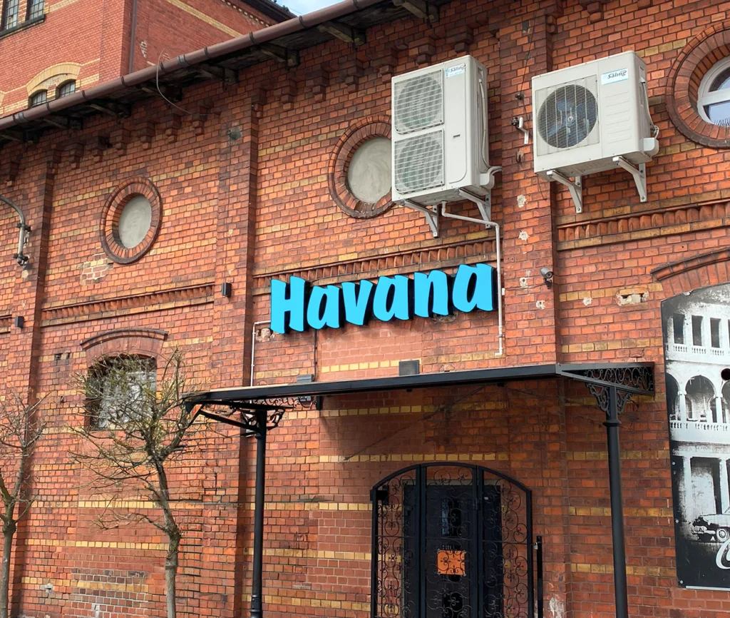 Logo HAVANA z podświetlanych liter przestrzennych na czerwonej ceglanej elewacji, realizacja przy ul. Moniuszki w Żarach